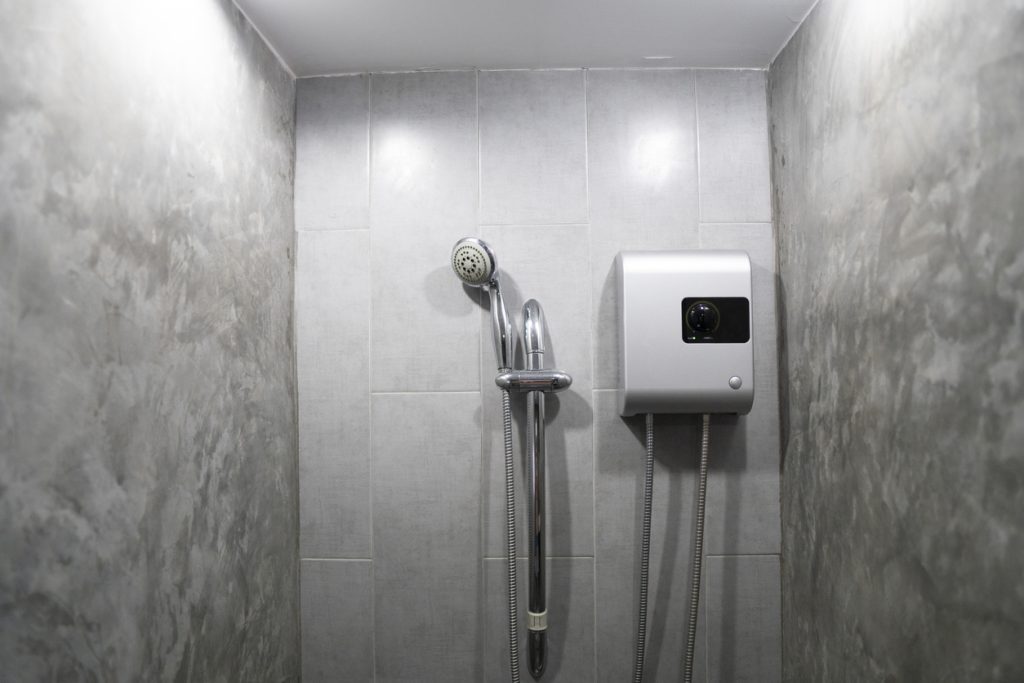 tankless water heater installed on grey tile wall